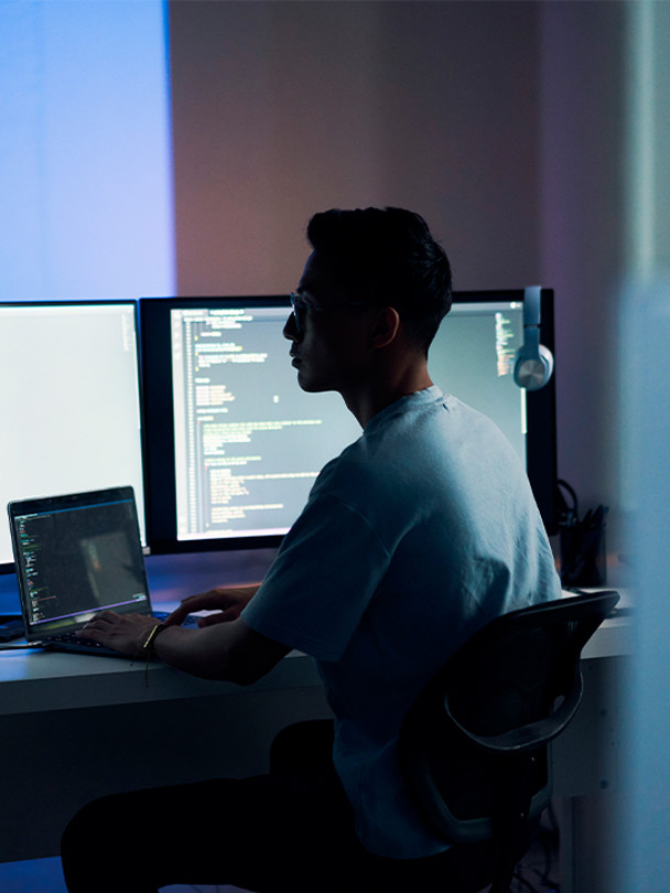 Scorpion Portrait 3 man working on laptop and monitors in dark