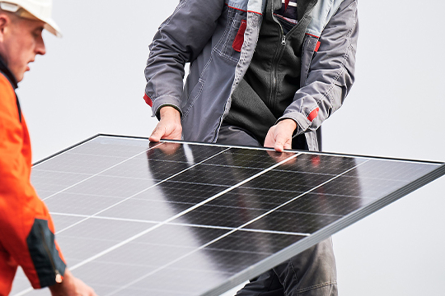 Solo Portrait 3 men lifting solar panel