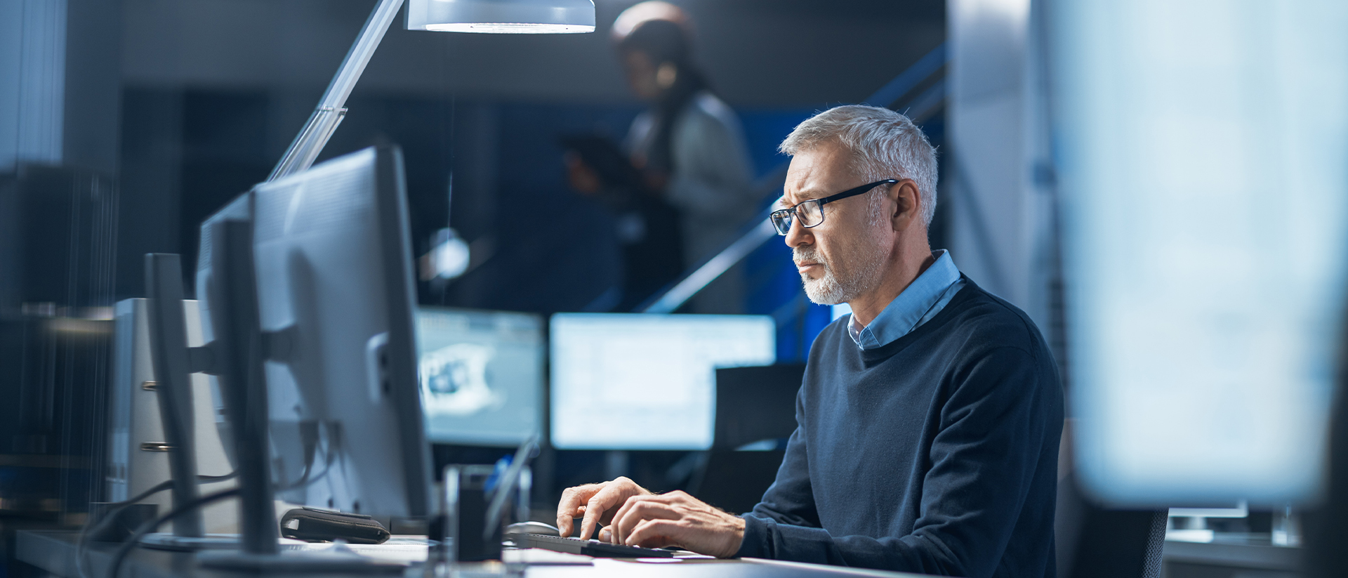 Kiteworks header image man working at computer screens