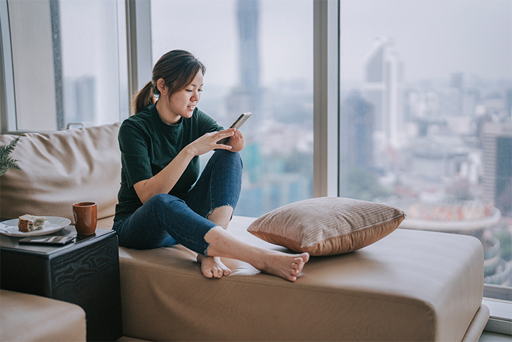 Buildinglink Landscape 1 woman on sofa texting