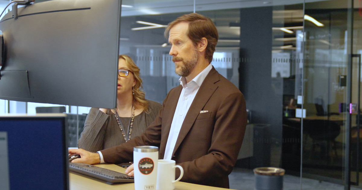Video still of people working on a computer